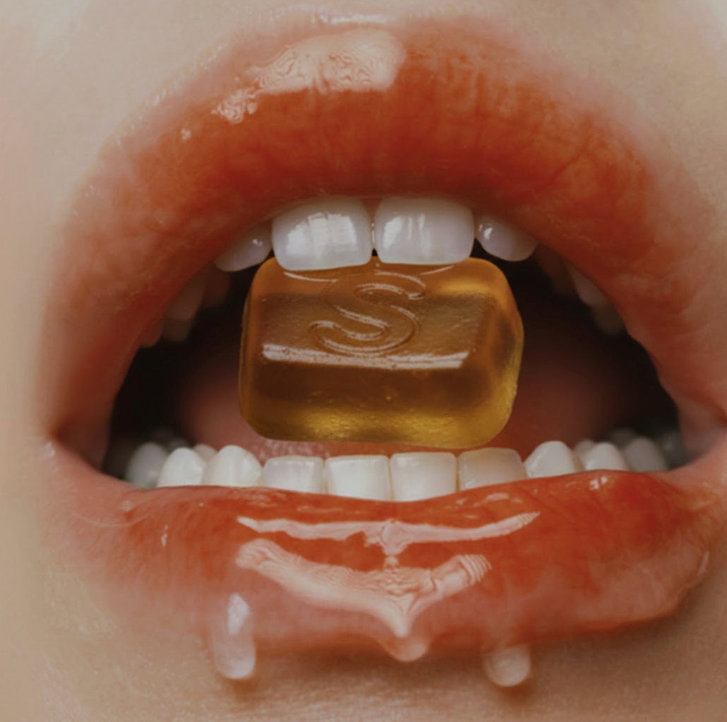 Close-up of a mouth enjoying a JUICY Sour Apple Gummy